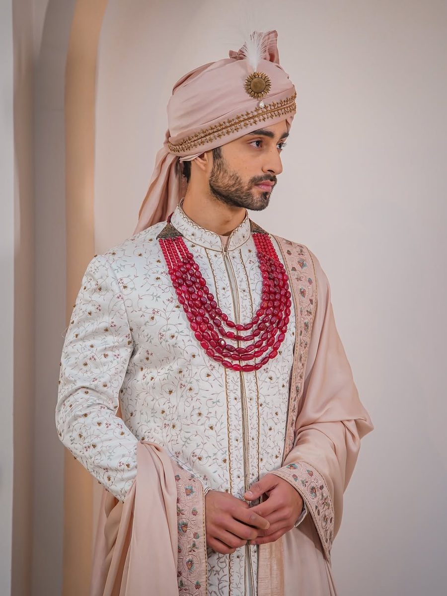 Groom profile shot in white sherwani